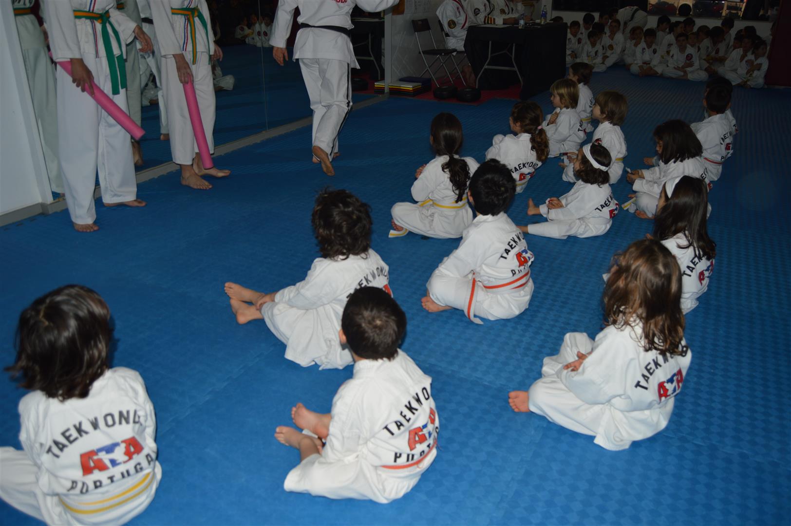 Crianças sentadas no tatami durante uma aula
